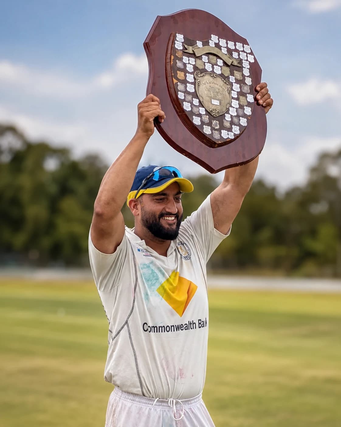 Willowdale player holding a championship shield above his head