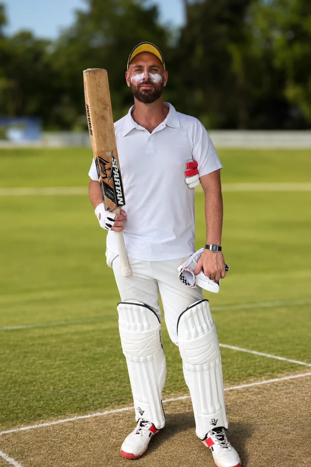 Senior cricket player holding a bat in match equipment